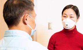 Clinician wearing PPE with patient
