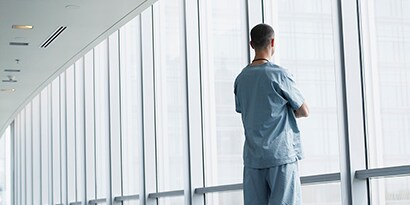 man looking out clean facility window
