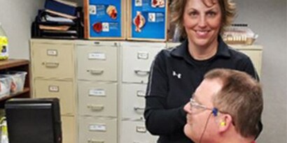 Hearing conservation specialist with a worker taking a hearing test
