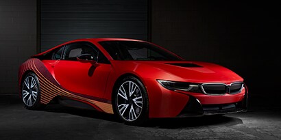 Sports car sitting in a dark showroom wrapped in a red 3M graphic wraps.