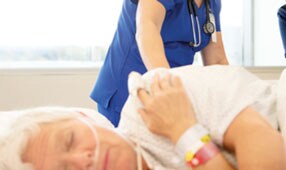 Clinician monitoring a patient with a pressure injury
