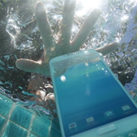 Hand reaching into a pool to grab a phone to show the water resistance of 3M's electronics bonding solutions.