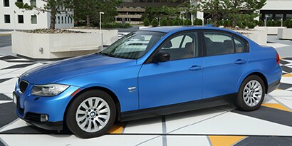 A small BMW beamer sedan wrapped in a blue 3M 1080 wrap film.