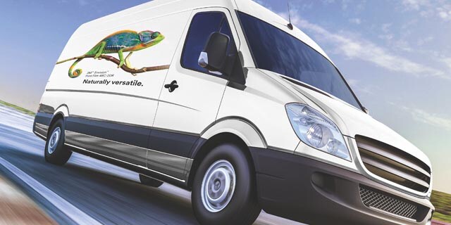  A big white van driving on a highway with a chameleon on the side of it using the 3M 48C graphic film.