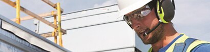 construction worker outside wearing earmuffs with wireless communication accessory
