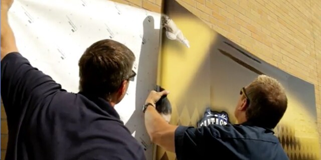 Person with blue surgical gloves spraying a paper towel with 3M enhanced adhesion spray
