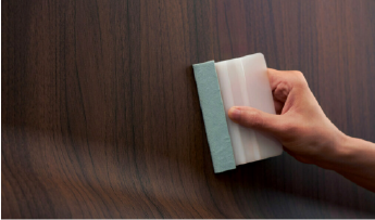 Someone applying a wood grain architectural film
