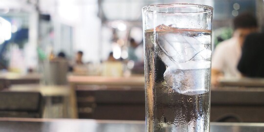 Glass of ice water on counter.
