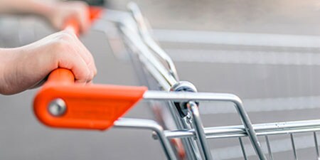 A person pushing a grocery cart that has been wiped with 3M Instant Microbe Removing Wipes.
