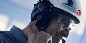 Worker wearing 3M protective communications in-ear earpiece operating machine
