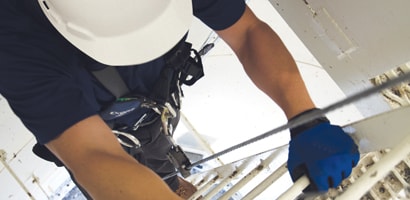 Worker climbing tower ladder using climb assist ladder system
