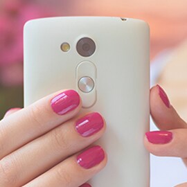 A person holding a smartphone up to show the camera, where 3M electronics camera lens bonding can be applied.