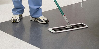 worker dusting facility floors
