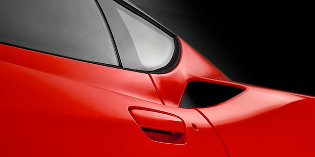 3M clear bra film applied to a red sports car
