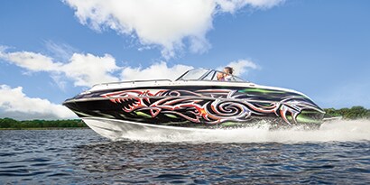 A speed boat on the water that is wrapped in a colorful flame 3M graphic boat wrap.

