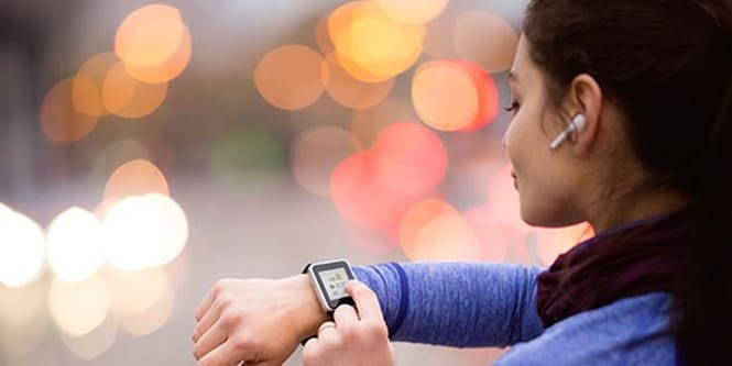 A woman using a smartwatch while exercising.
